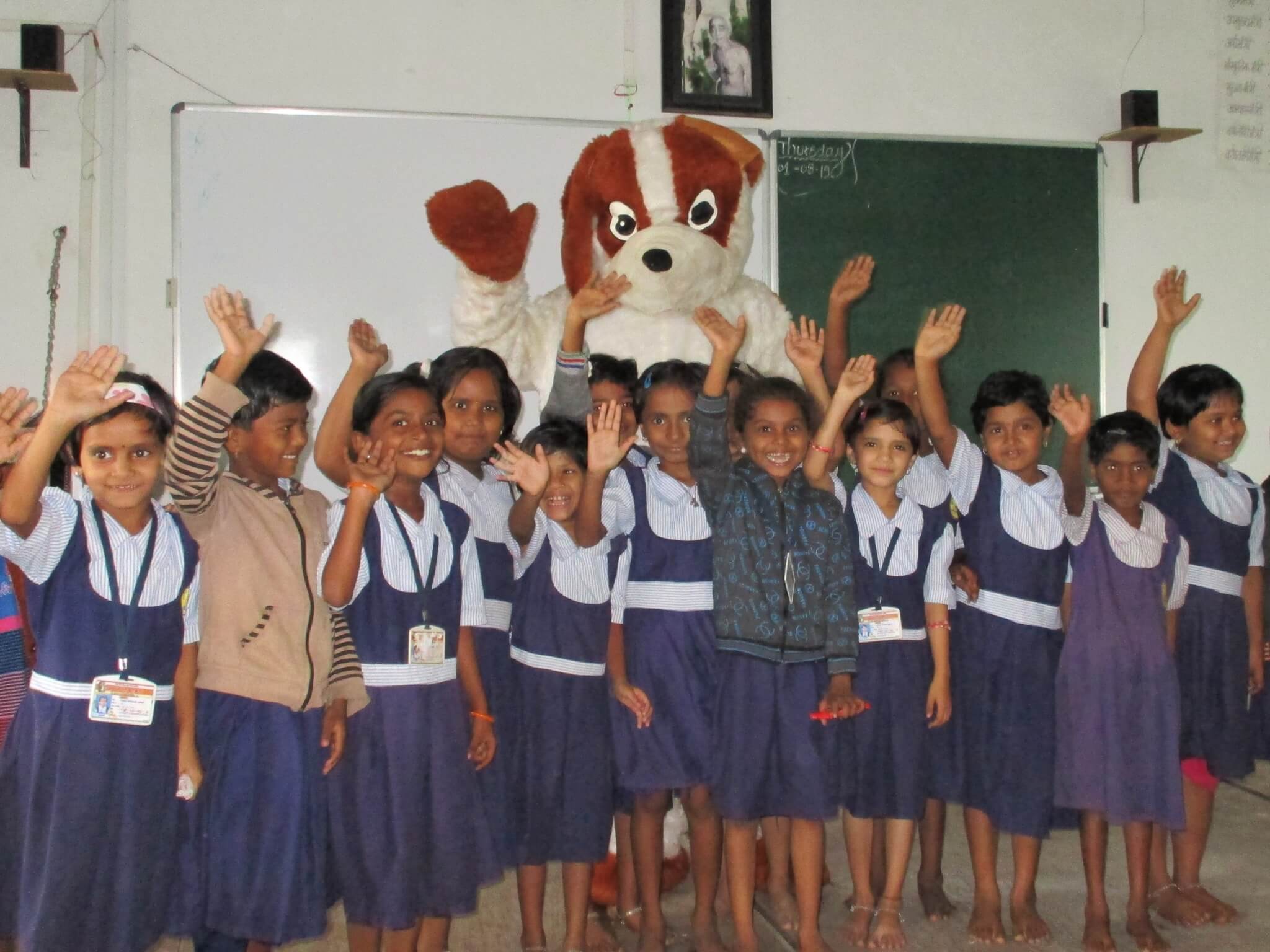 Students grin as they raise their hands in a pledge to be kind to animals.